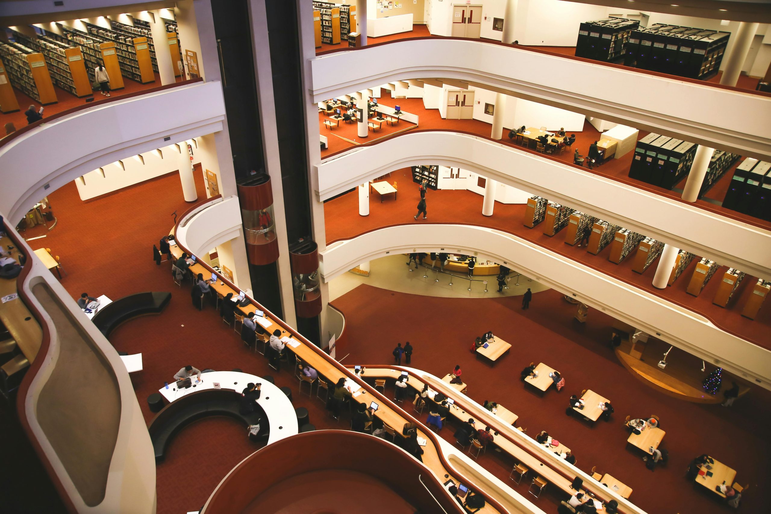 Aerial view of a multistory library interior with people studying at tables in Toronto.